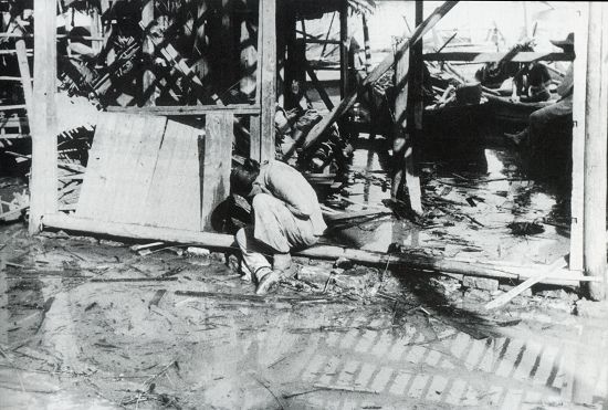 1938年7-9月间，汉口，一次日军的空袭之后，在被毁的家园前哀伤的妇女。