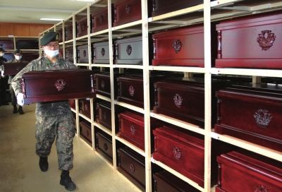 3月27日，韩国坡州市志愿军遗骸临时安置所，韩国士兵将棺椁起运装车。新华社发