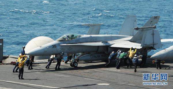 美军开始对伊拉克极端组织发动空袭这张美国海军8月8日提供的照片显示，在海湾地区执行任务的“乔治·H·W·布什”号航空母舰上，地勤人员指挥一架F A-18C大黄蜂战斗机。新华社发