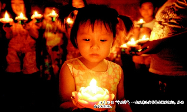 8月10日“中元节”，一名天津儿童手捧点燃的河灯，为云南鲁甸祈福。