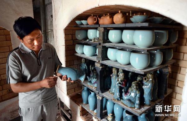 钧瓷工艺大师王建伟在检查刚出窑钧瓷产品的釉色。