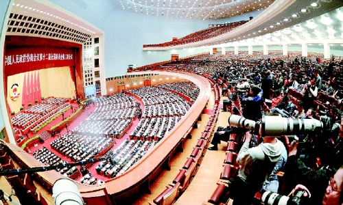 三月十三日，新闻工作者在会场报道全国政协十二届三次会议闭幕会。    本报记者  田福良  摄