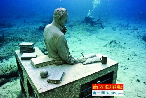 游客背着呼吸器深入水中观看雕塑。