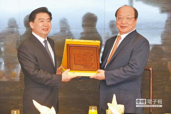 旺旺集团副董事长胡志强（右）致赠纪念品给广东省政协主席王荣（左）。（记者李锌铜摄）