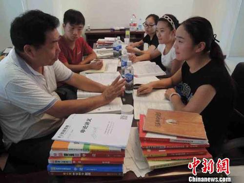 图为在中牟县城一个小区的学习点，几名正在准备公考的考生正在和郭宗强进行交流。