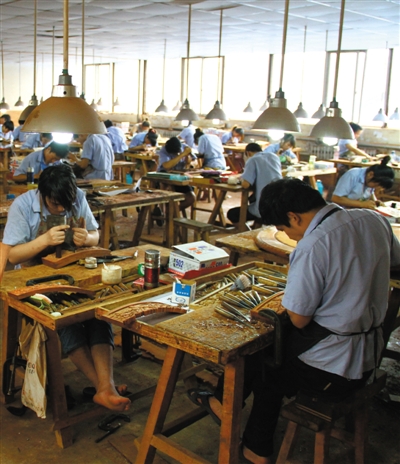 红木家具厂内，工人正在进行雕刻。京作家具继承了明式家具结构造型方面的优点，更加突出了雕刻装饰功能。资料图片