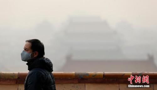 12月7日，一名戴口罩的游客在北京景山游览。当日，北京市应急办于当日18时发布空气重污染预警等级由橙色提升为红色的消息，即全市于12月8日7时至12月10日12时将启动空气重污染红色预警措施。这也是北京市首次启动空气重污染红色预警。 中新社记者 盛佳鹏 摄