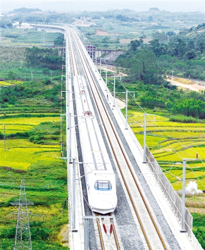 　12月3日，一辆试运行的“和谐号”列车从广西南宁市隆安县境内的一座高架桥经过。韦万忠摄（新华社发）