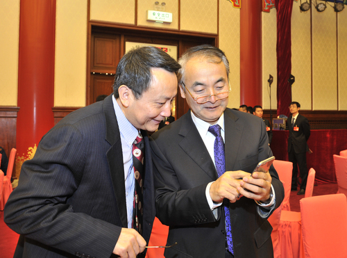 贾庆国和葛剑平相见在新年茶话会上，通过手机留影纪念2015年
