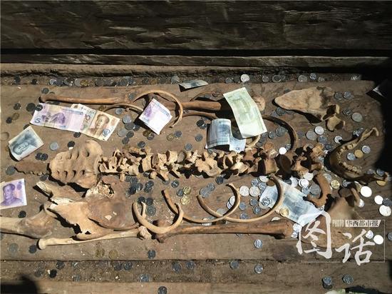 悬棺里古人遗骸摆放的位置都被这些堆满的人民币遮挡。 记者谭曦 图片来源：华西都市报