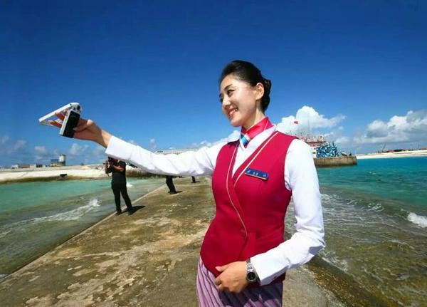 空姐在永暑礁上进行自拍。 新华社记者 查春明 摄 图片来源：中国军网