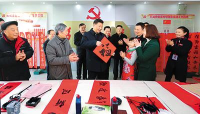 2016年2月3日，习近平在江西省南昌市东湖区彭家桥街道光明社区书画室，接过一位小朋友现场书写的“福”字，祝大家幸福。
