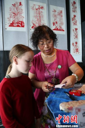 (资料图)2013年7月21日，齐秀花随山东省民间文化代表团访问冰岛向当地民众展示山东传统绝活剪纸艺术。　邱江波 摄