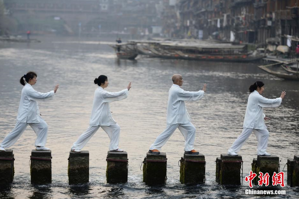 2月6日清晨，湖南凤凰县太极协会的太极拳爱好者们在凤凰古城的沱江边打起了太极，以此迎接即将到来的春节，呼吁大家健康养生。 杨华峰 摄