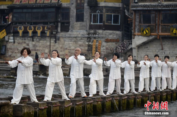 2月6日清晨，湖南凤凰县太极协会的太极拳爱好者们在凤凰古城的沱江边打起了太极，以此迎接即将到来的春节，呼吁大家健康养生。 杨华峰 摄1