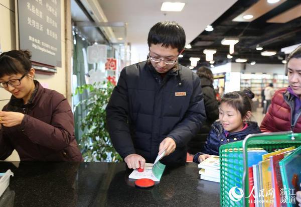 图书管理员给新书加盖杭州图书馆公章。