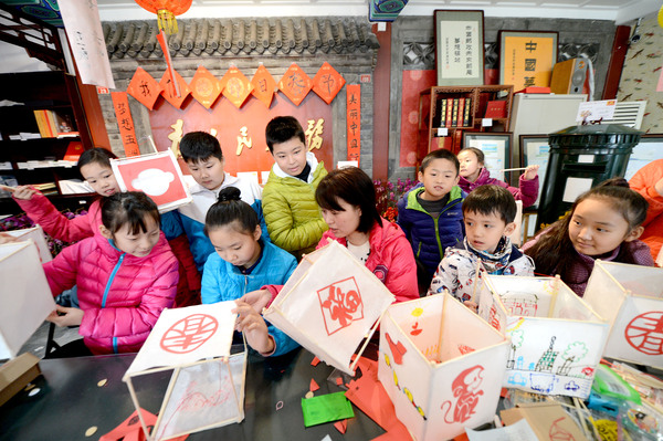 1A图为孩子们在北京的梦想驿站里扎灯笼，体验民俗。