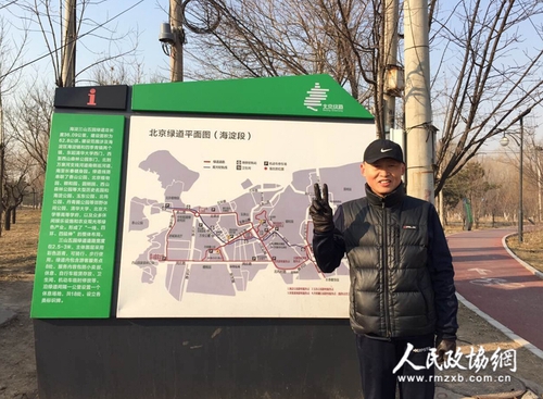 王名委员在北京绿道平面图（海淀段）前留影。 赵莹莹 摄_副本