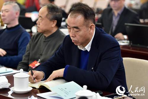 全国政协委员陈凯歌在小组讨论会上认真做笔记。（记者 翁奇羽 摄）