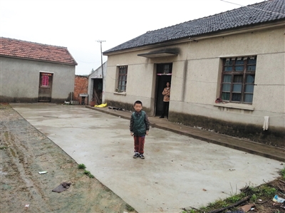 养子6岁时在亲生父母家门前的留影。李征琴见表妹家困难，主动提出收养孩子。