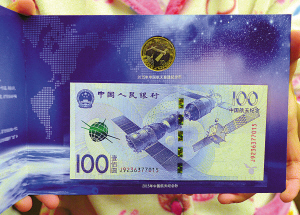 市民王小姐向记者展示其收藏的航天纪念币（钞）。（陈章升 摄）