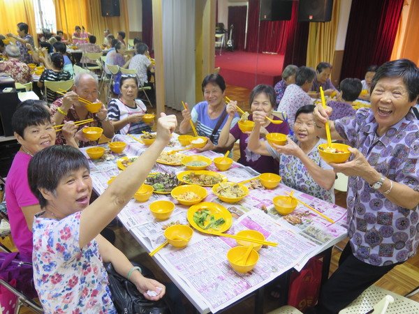 今年春节，街坊总会组织青年为老年人做年饭，老人们在一起欢度节日。