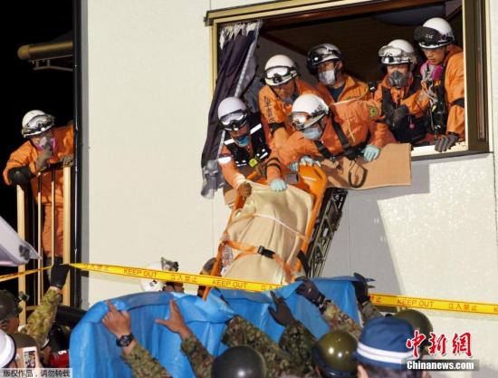 救援人员用担架将一名在地震中受伤的女性抬出危楼。