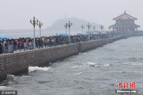 看海还是看人海？4月30日，青岛栈桥的小清新气息全无，只剩下缓慢挪动的各位尽情享受无尽的海风。 图片来源：视觉中国