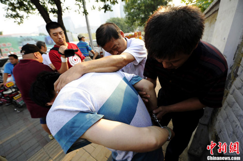 质料图：2013年8月北京西城警方在儿童医院抓获8名号贩子。图片来源：CFP视觉中国
