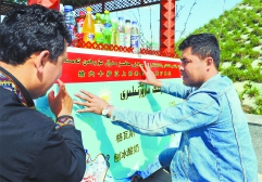 4月10日，阿合买提江在自己的摊位前张贴爱心宣传板。