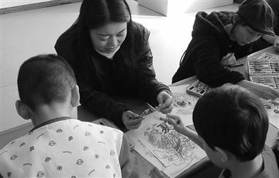 翟月正在指导自闭症儿童涂画她设计的中国版“秘密花园”