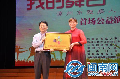 漳州市 委副书记林文耀为艺术团成立授牌，艺术团团长朱丽娟接牌
