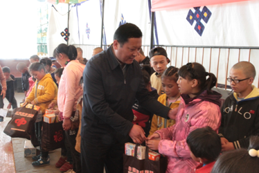 自治区民政厅副厅长尼玛次仁为孩子们发放慰问品