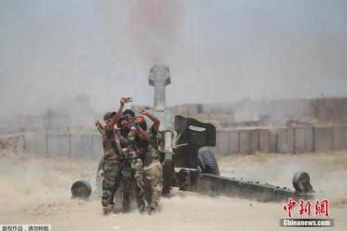 图为伊拉克军队士兵在重炮前自拍。