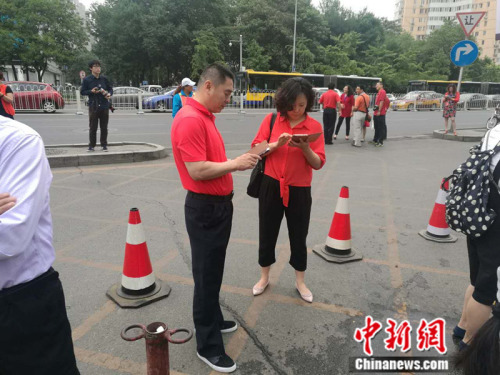 2016年6月7日，人大附中考场外，有家长专门穿红衣“送考”。 张尼 摄