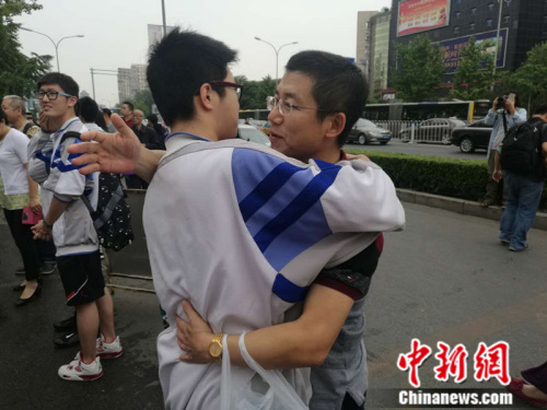 2016年6月7日早，人大附中考点外，一名考生进考场前与家长拥抱。 张尼 摄