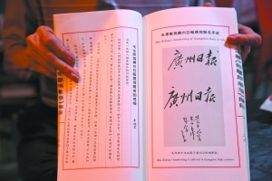 屈干臣展示毛泽东为广州日报题写的报名手迹（原手迹收藏于广州日报档案室）