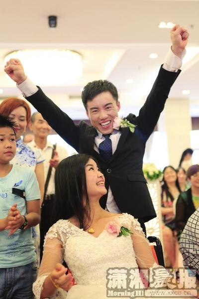 6月25日，张伟兴奋地举起双手大声呼喊“我们终于结婚了”。图/记者金林