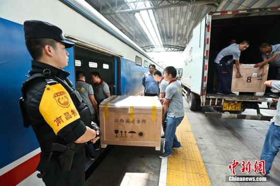 图为6月29日，在北京站，文物保护人员将海昏侯文物搬运上列车。 张学东 摄
