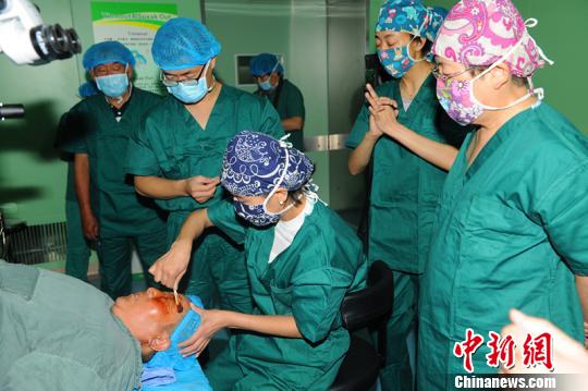7月2日，黎晓新(右)等专家指导西藏自治区藏医院眼科医生开展玻璃体切除手术。　曾彬 摄