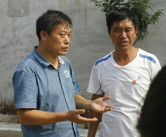 杨牌村党支部书记向范德俊介绍该村受灾情况。