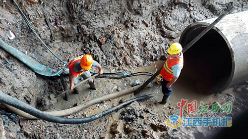 工作人员对挖断的电缆线进行抢修。 中国江西网 图