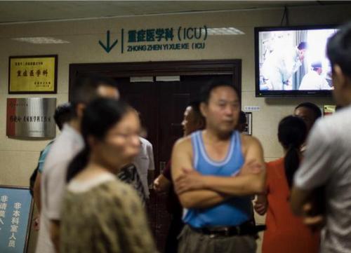 8月11日，事故受伤人员家属在当阳人民医院ICU病房门口等待伤员救治的消息。