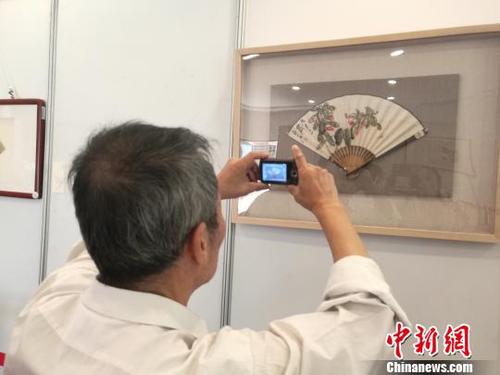 图为中国书画家协会理事、台湾中华大汉书艺协会特聘书画大师翟因钦在拍照。　苏路程 摄