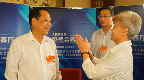 全国政协副主席刘晓峰（左一）了解报道情况