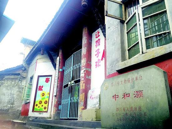四川省文物保护单位中和灏的石碑与幼儿园的牌子并存。刘亿 摄