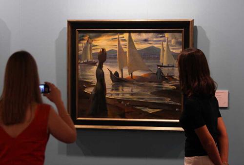 一位女士正在拍摄埃及画家穆罕默德·赛义德 （Mahmoud Said， 1897-1964） 作品《卢克索尼罗河上的日落》 （Sunset on the Nile at Luxor）。该画作竞得了 90.25 万美元（约合人民币608.29 万元），远超其 8 万至 12 万美元（约合人民币53.92 万至 80.88 万元）的拍前预估。