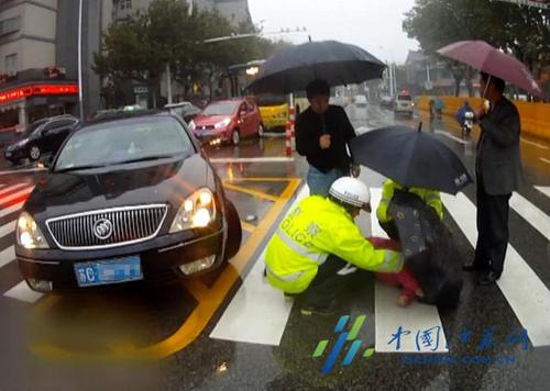 江苏徐州女子雨中被撞倒地 民警为其撑伞遮雨
