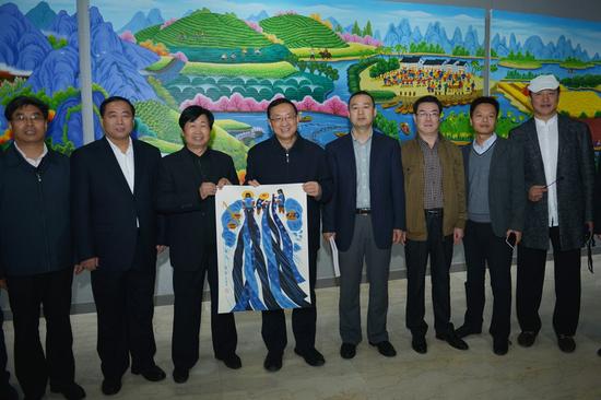 雒树刚部长一行亲切和农民画作者在他们创作的主题画前合影