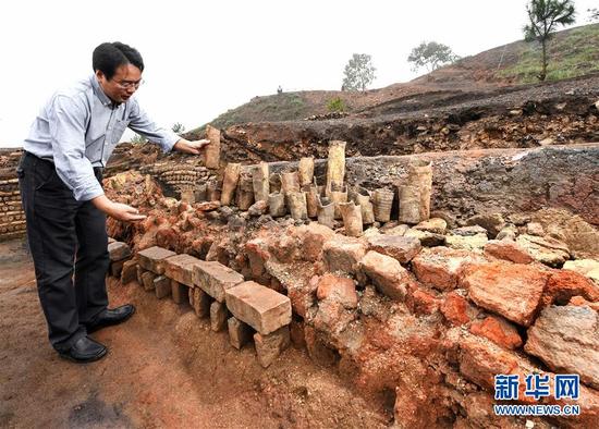 在桐木岭矿冶遗址，考古工作者在展示用于提炼矿物的坩埚（11月18日摄）。